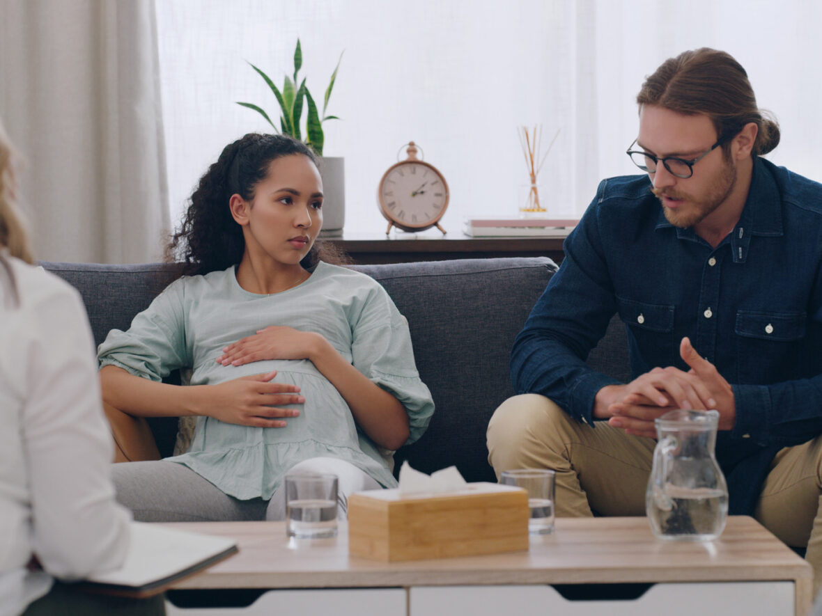 A pregnant couple sitting in a counseling session