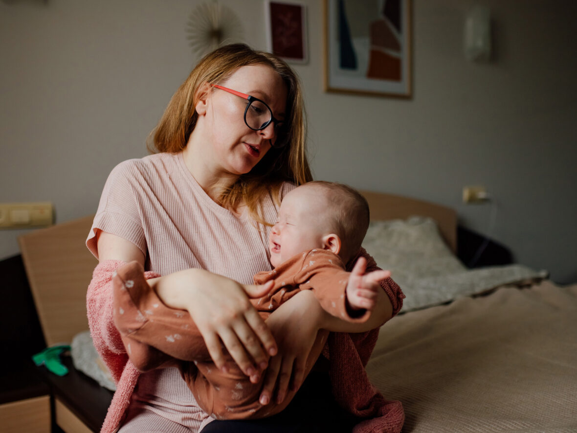 A woman trying to console her crying baby