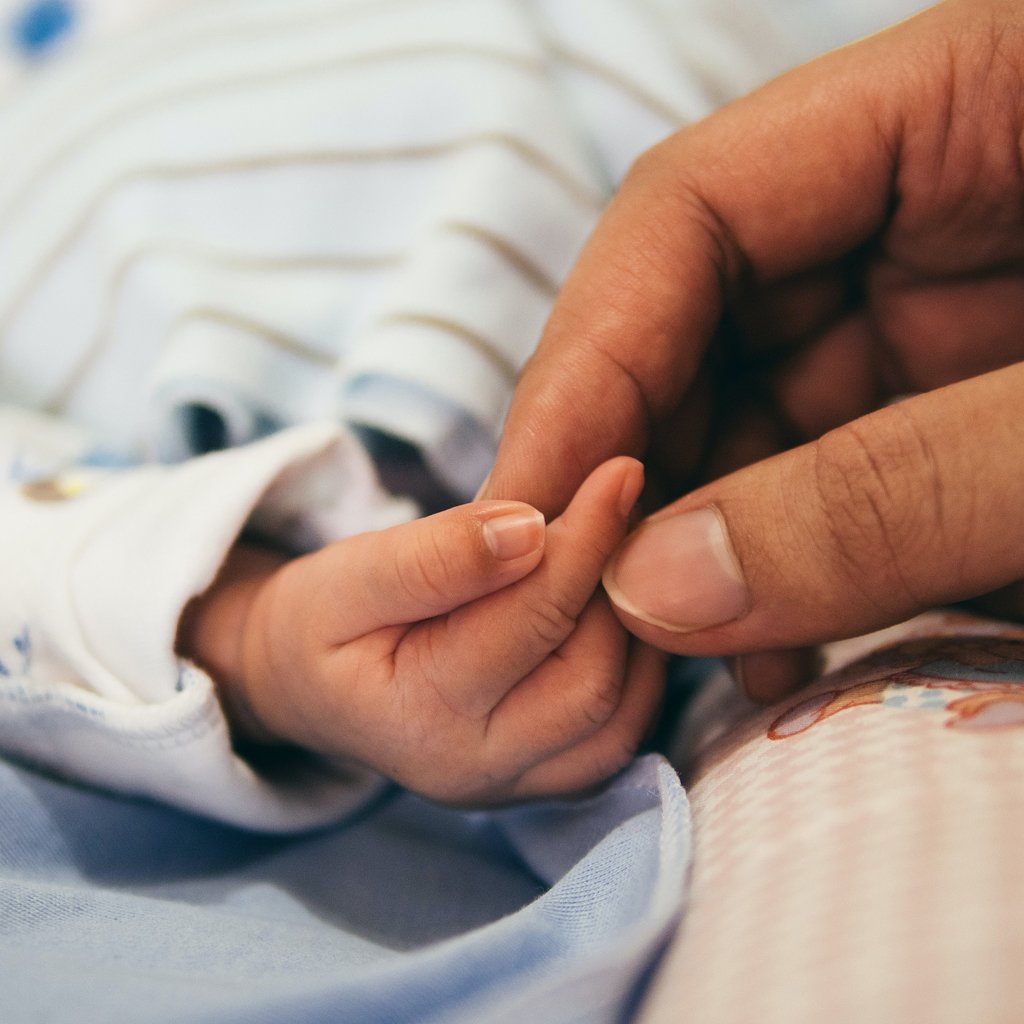 Mom holding new born baby hand