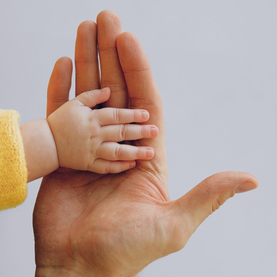 Mom holding newborns hand